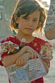 An Iraqi girl holds a Beanie Baby and a handbill given to her by Iraqi soldiers from the 1st Battalion, 4th Public Order Brigade during Operation Thunder Goodwill Aug. 17. Photo by U.S. Army Spc. David Kobi, 55th Signal Company